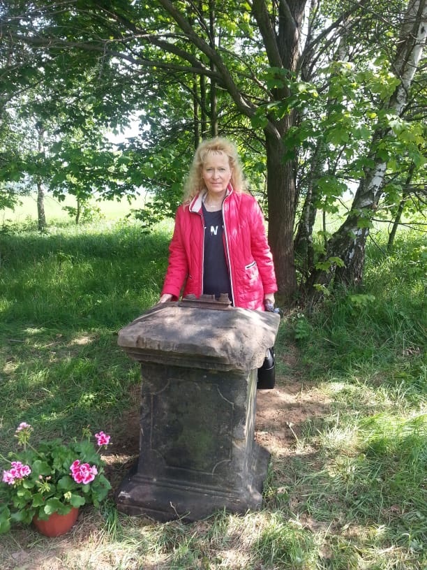 Renate von Babka mit dem Gedenkstein ihres Ururopas Karl Beil in der Nähe von Peterswald - Foto: privat