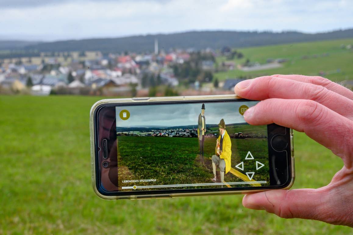 Die App „Lebendiges Erzgebirge“ macht Anton Günther wieder lebendig, hier im Gespräch mit einem Journalisten, im Hintergrund Gottesgab (Boží Dar). Foto: Uwe Mann