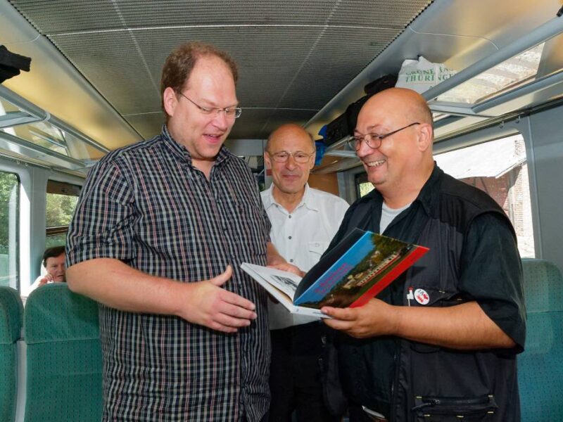 Andreas Petrak (rechts) schaff t als Autor und Verleger unermüdlich. Hier beglückwünscht er Leser seiner Böhmischen Reihe anlässlich einer Sonderzugfahrt (mit ihm als Reiseleiter) durch die tschechische Euregio Egrensis. Foto: Frank Barteld