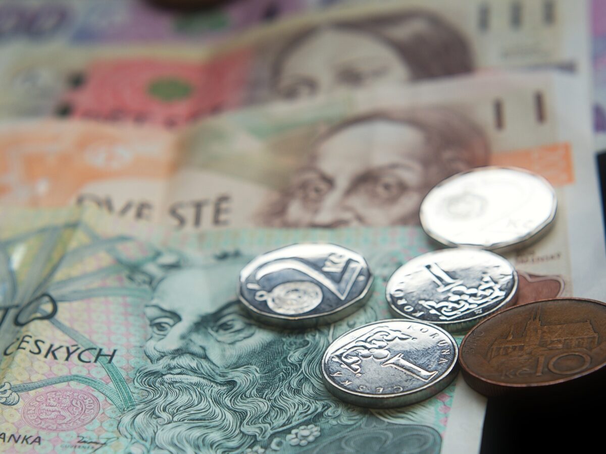 Die Landesewährung in Tschechien sind Tschechische Kronen (CZK). Zu sehen sind fünf Geldmünzen und Geldscheine.