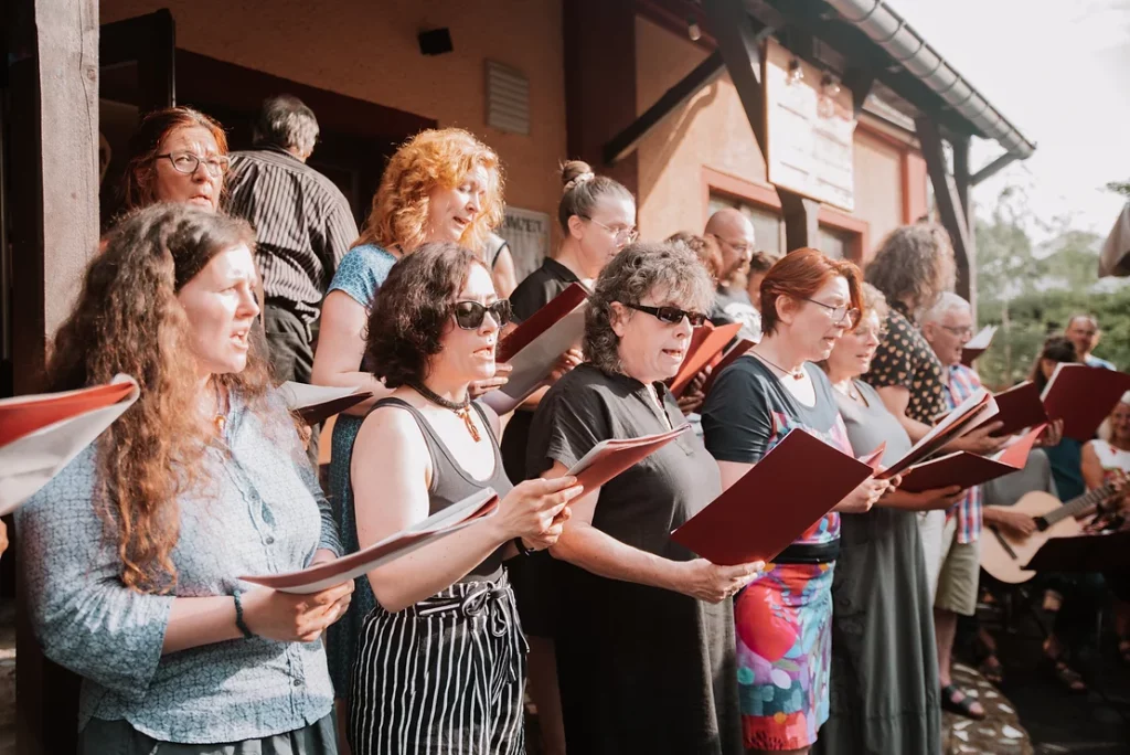 Eine Gruppe von Frauen singt aus Gesangsbüchern.