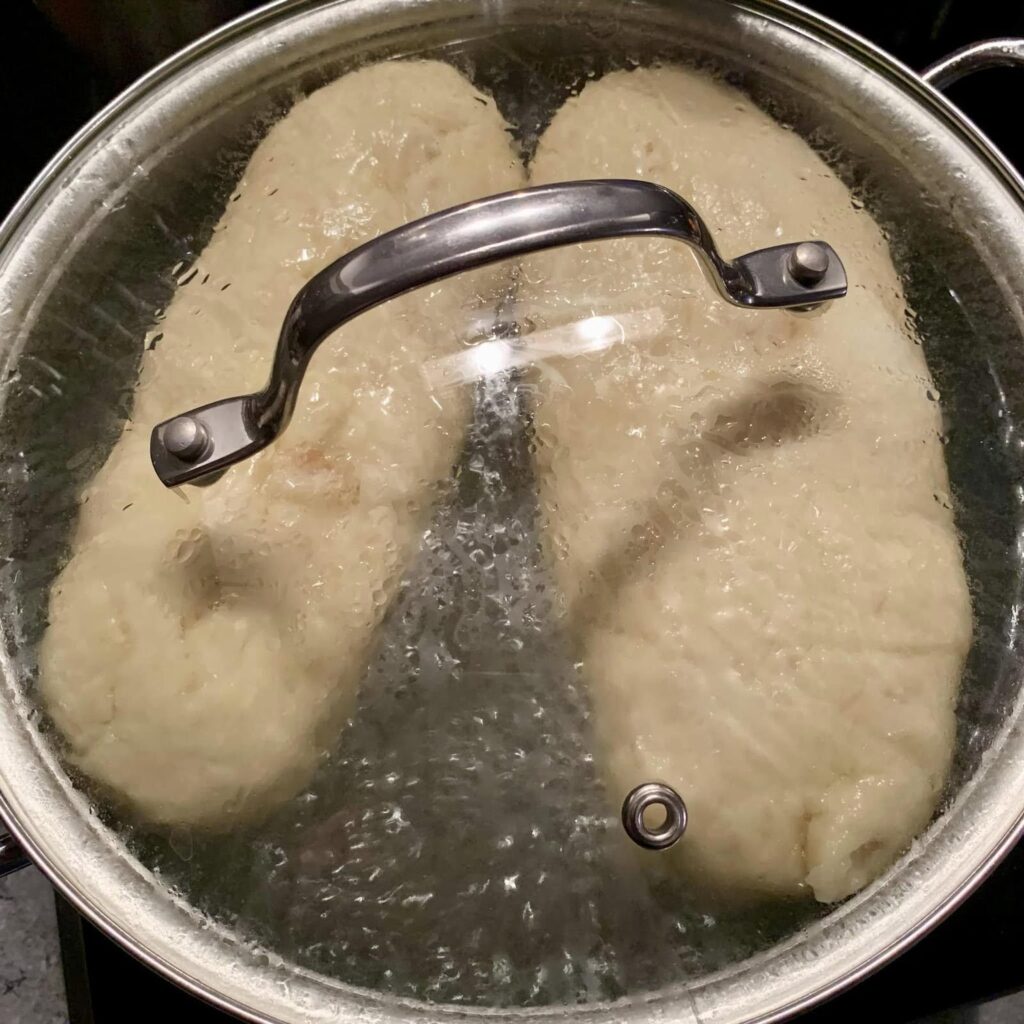 Böhmische Knödel in einem Kochtopf mit Deckel.