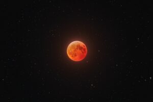 Eine Mondfinsternis tritt dann auf, wenn der Mond in den Schatten der Erde eintritt. Der Mond erscheint dann rötlich.