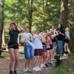 Jugendliche balancieren gemeinsam auf einem Seil im Niedrigseilgarten beim deutsch-tschechischen Sommercamp 2025 in Waldmünchen.