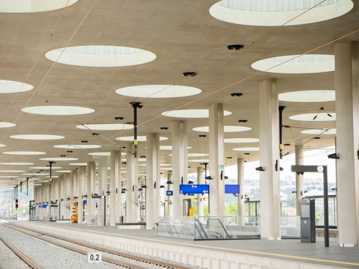 Die Bahnsteighalle des Bahnhofs Praha–Bubny. Das Design mit zahlreichen Säulen und runden Deckenöffnungen sorgt für Helligkeit und eine offene Atmosphäre.
