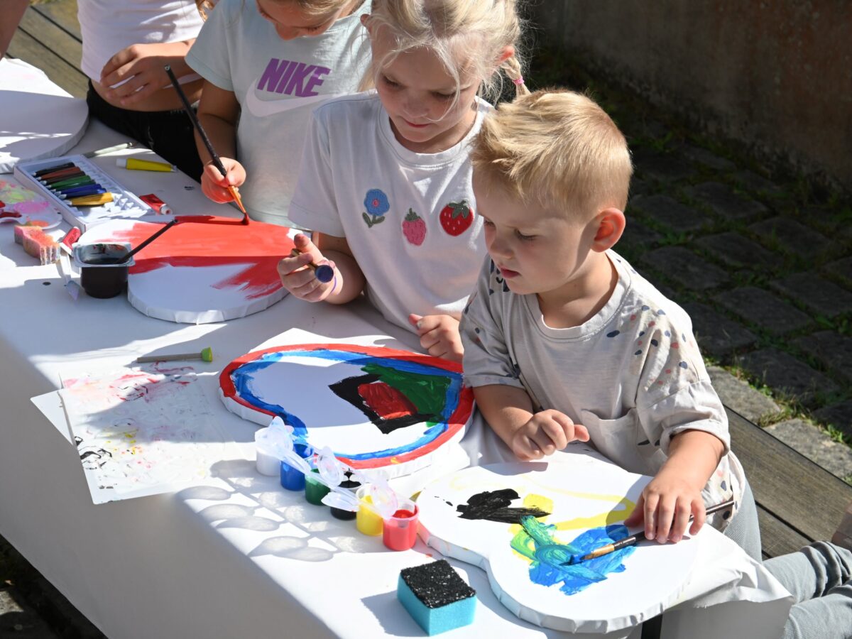 Kinder bemalen Herzen beim 35-jährigen Jubiläum der Deutschen Schule Prag.