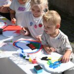 Kinder bemalen Herzen beim 35-jährigen Jubiläum der Deutschen Schule Prag.