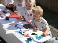 Kinder bemalen Herzen beim 35-jährigen Jubiläum der Deutschen Schule Prag.