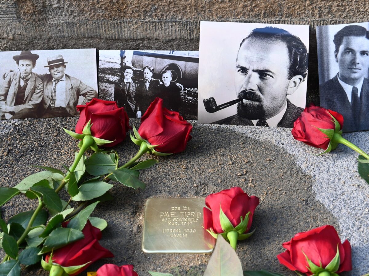 Der neue Stolperstein für Pavel Tigrid in der Kouřimská-Straße in Prag-Vinohrady. Rote Rosen und Familienfotos erinnern zugleich an die vielen Angehörigen der Familie Schönfeld, die Opfer der Shoah wurden.