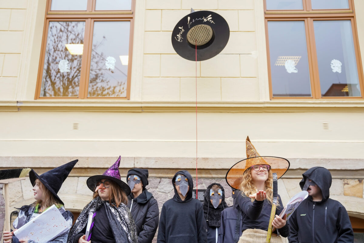 Schülerinnen und Schüler stehen in Kostümen vor dem magischen Hut.