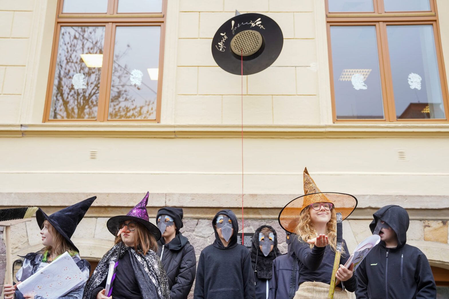 Schülerinnen und Schüler stehen in Kostümen vor dem magischen Hut.