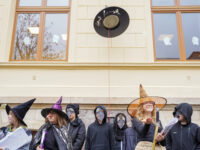 Schülerinnen und Schüler stehen in Kostümen vor dem magischen Hut.