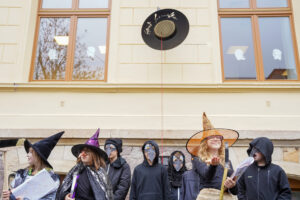 Schülerinnen und Schüler stehen in Kostümen vor dem magischen Hut.