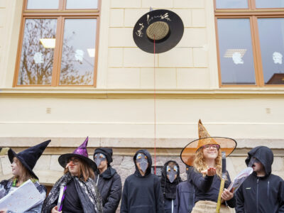 Schülerinnen und Schüler stehen in Kostümen vor dem magischen Hut.