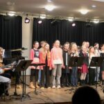 Schülerinnen und Schüler untermalten die Veranstaltung mit einstudierten Liedern.
