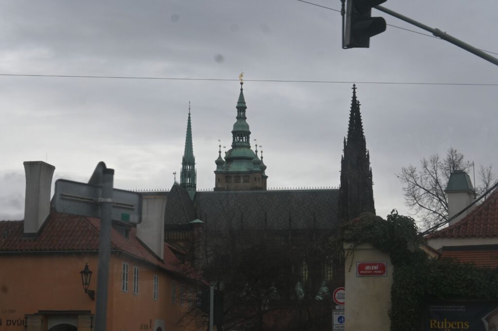 Aus der Ferne ragt die Prager Burg hervor.