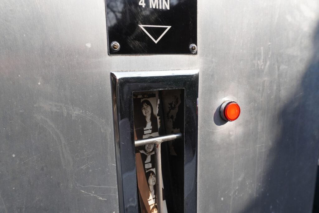 Das endgültige Bild fällt in ein Fach am Äußeren des analogen Fotoautomaten.