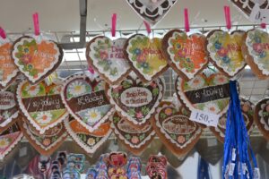 Die typischen, mit weißem Zuckerguss verzierten Lebkuchenherzen, welche mit Gemälden und Botschaften verziert sind.