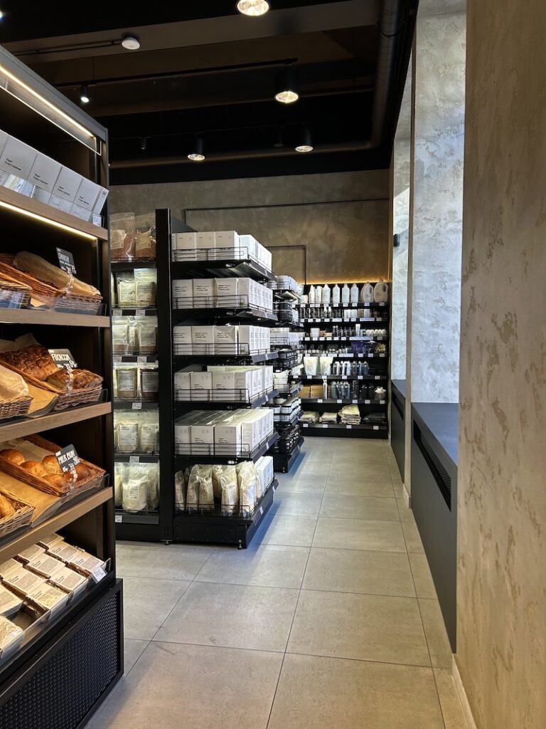 Der Laden ist mit schwarzen Regalen und einem minimalistischen Design eingerichtet.