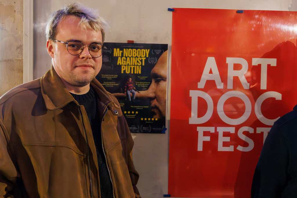 Pavel Talankin bei der Eröffnung des Dokumentarfilmfestivals ArtDocFest in Paris am 17. November 2025. Hinter ihm ist das Festivalplakat zu sehen. Sein Film „Mr Nobody Against Putin“ war der Eröffnungsfilm der Veranstaltung.