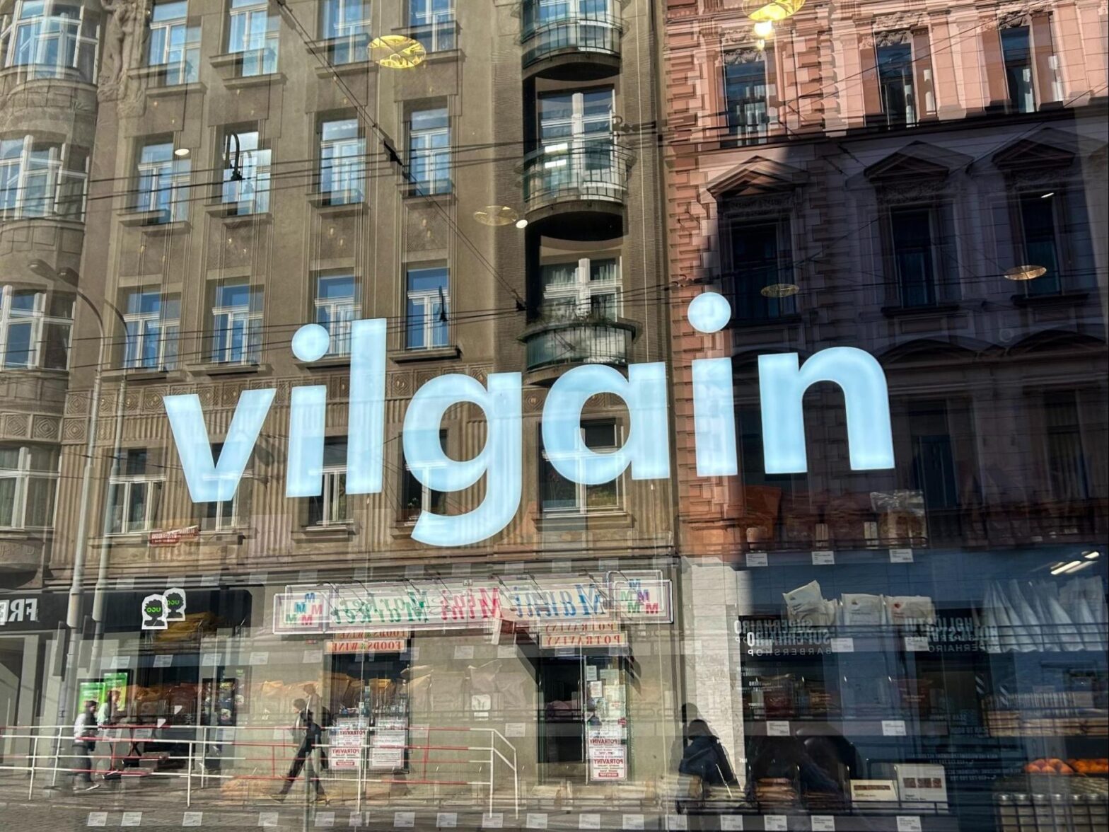 Der weiße Schriftzug scheint grell in den Fenstern des Ladens.