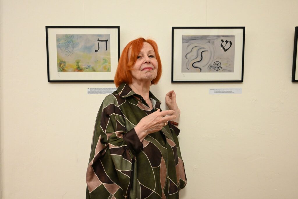 Die Dresdener Künstlerin Lieselotte Theil-Hurshell neben einem ihrer 22 Bilder der „ALEF-BET"-Ausstellung.