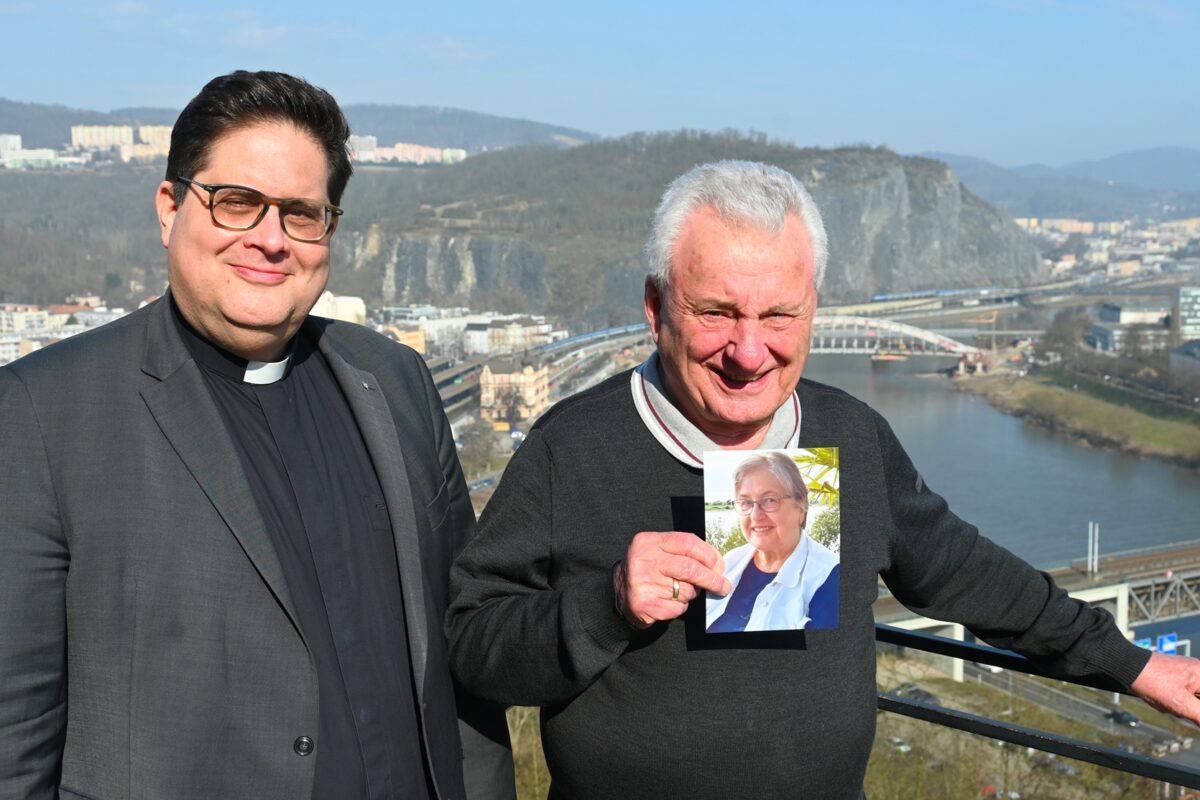 Klaus Hopmann (r.) und sein Sohn Tobias auf der Terrasse des Hotels Větruše in Aussig (Ústí nad Labem). In den Händen hält Klaus ein Foto seiner Frau Helga, die während eines gemeinsamen Besuchs ihrer Heimatstadt im August 2025 verstarb.