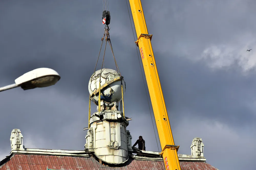 Mitarbeiter der Baufirma lassen den Globus mittels Kran zur Straße hinunter. Foto: Stadtmuseum Aussig/Jiří Preclík