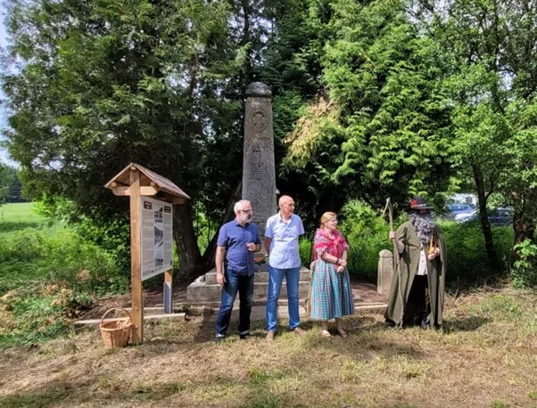 Erik Buchholz, Josef Bitnar, Štěpánka Šichová und Rübezahl (v.l.n.r.) stehen neben einer der Informationstafeln, die an den wiederbelebten Ort Liebenau erinnern soll. Foto: Andreas Breuer