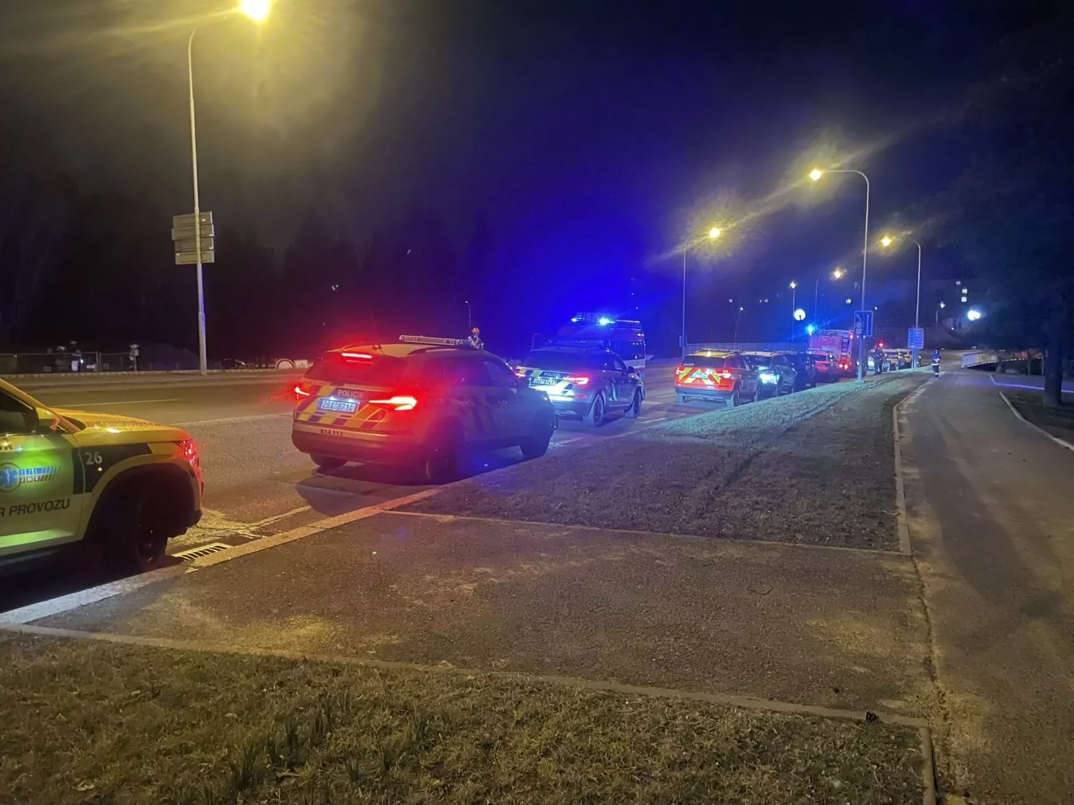 Ein tschechisches Polizeiauto parkt mit Blaulicht am Straßenrand.