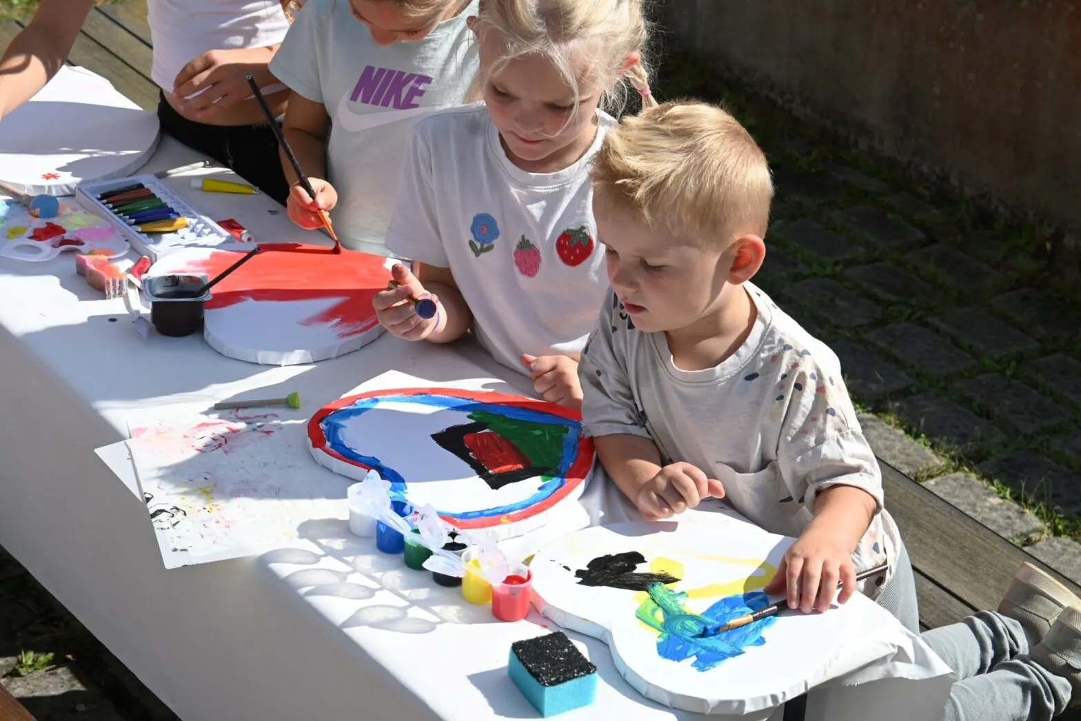 Kinder bemalen Herzen beim 35-jährigen Jubiläum der Deutschen Schule Prag.