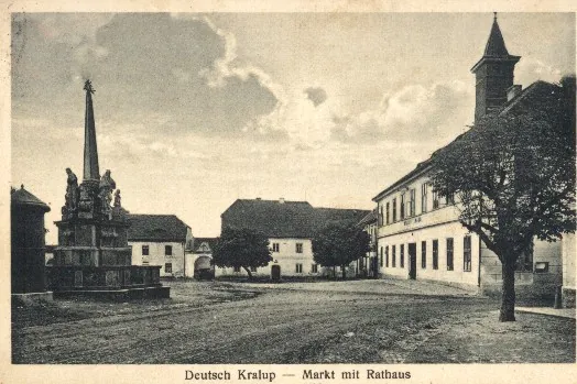 Deutsch Kralupp war eine Kleinstadt in der Nähe von Komotau. Nach dem Zweiten Weltkrieg wurde die deutsche Bevölkerung größtenteils vertrieben. In den 1960er Jahren fiel der Ort dann dem fortschreitenden Braunkohletagebau zum Opfer. Die Dreifaltigkeitssäule, die am Marktplatz stand, steht heute in Zelená, einem Ortsteil von Malkau (Málkov).